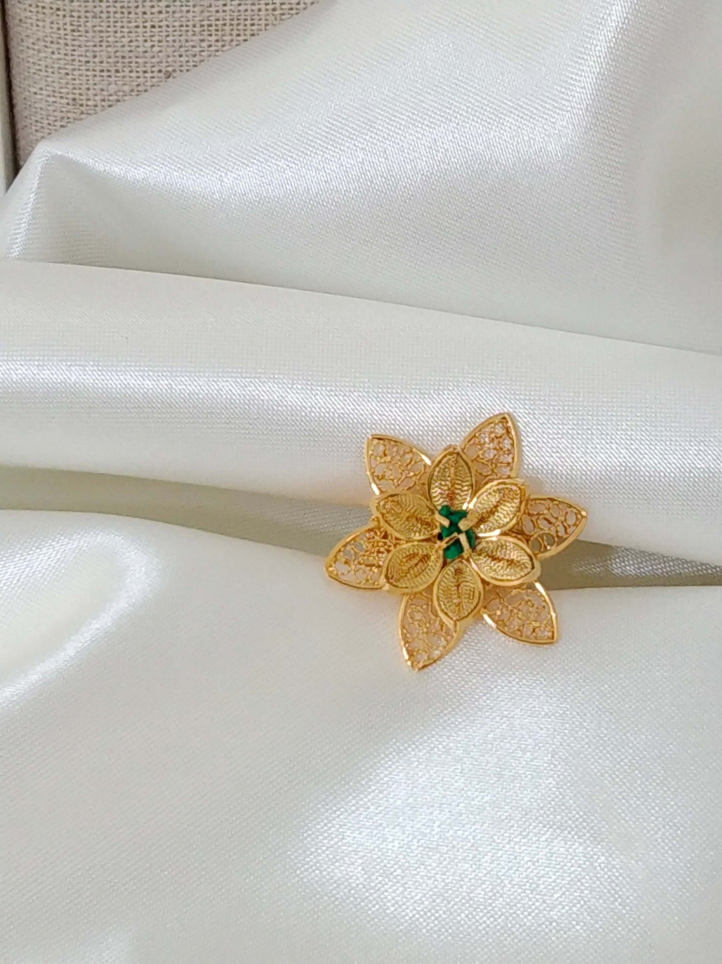 Ladies ring in the shape of a flower with an emerald cut filigree