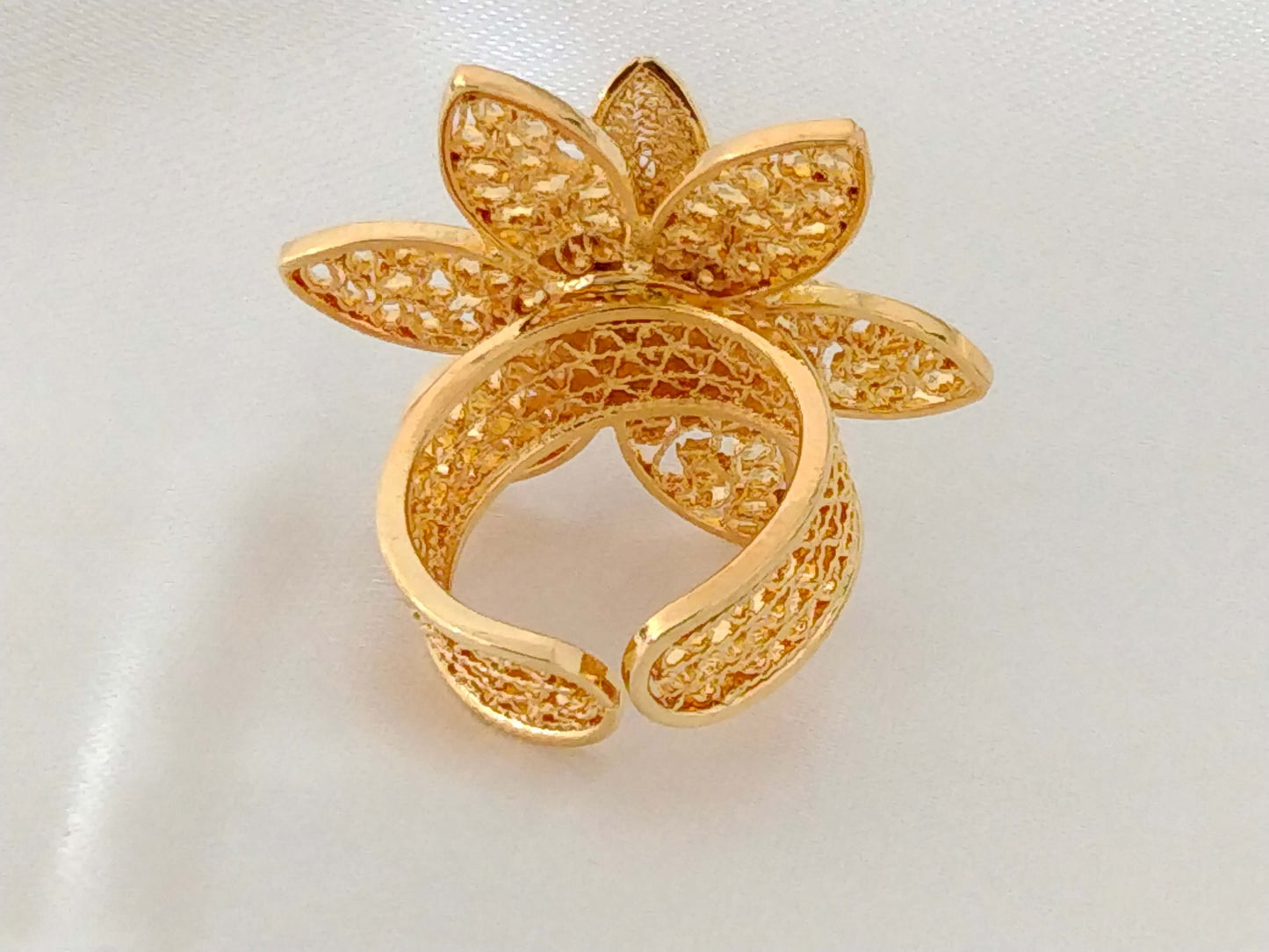 Ladies ring in the shape of a flower with an emerald cut filigree