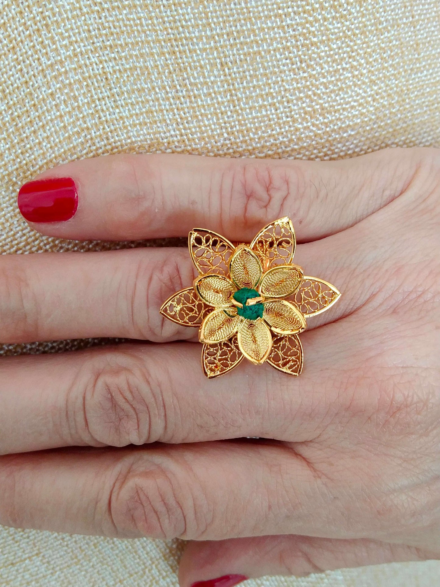 Ladies ring in the shape of a flower with an emerald cut filigree