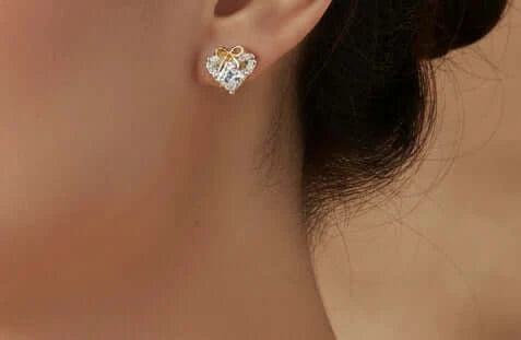 Lazos de Amistad - Aretes de Rodio estilo corazón con detalles dorados y piedras brillantes.