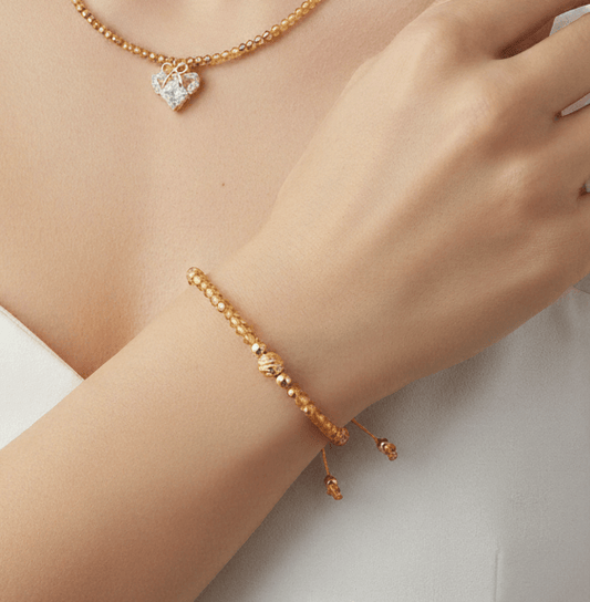 Lazos de Amistad - Pulsera de cristales, pulsera dorada en la muñeca de una mujer con collar.